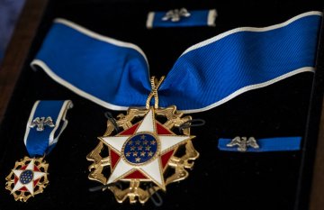 A Presidential Medal of Freedom displayed in a frame