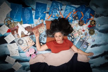 A woman in a red shirt lays on top of an assorted item set